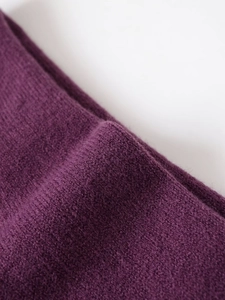 Detailed close-up showing soft purple knit fabric texture of the off-shoulder sweater