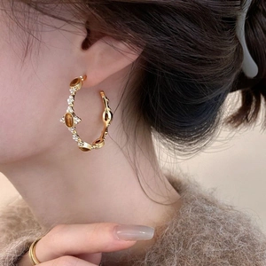 Detail of 18k gold plated hoop earring with tiger eye stone and small zircons