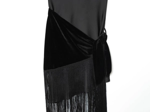 Detailed view of black velvet patchwork dress with side knot and long fringe tassels