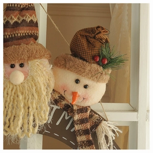 Detail of plush Santa and Snowman ornaments with warm knit textures and festive embroidery