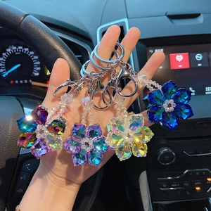 Detailed view of four colorful crystal snowflake keychains held in a car interior