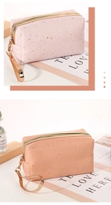 Detail of star pattern cosmetic bags in pink and peach with gold zipper and handle