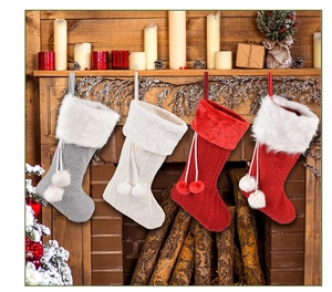 Détail de chaussettes de Noël en tricot rouge et blanc accrochées à une cheminée en bois