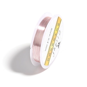 Detail of 0.4mm rose gold copper wire for DIY jewelry making on a white spool
