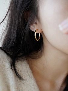 Close-up of elegant gold hoop earrings worn by a model showcasing French style design