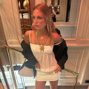 Elegant white chiffon mini dress paired with black blazer and gold layered necklaces
