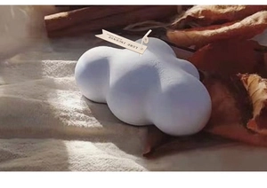 Vela aromática en forma de nube con etiqueta Lure Incense sobre fondo de tela de punto