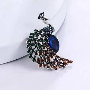 Gros plan détaillé d'une broche paon vintage avec cristal bleu et incrustation d'émail