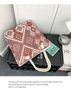 Detail of colorful geometric embroidery on canvas bag with white cotton rope handle