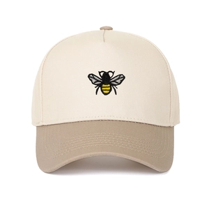 Close-up of a two-tone trucker cap featuring a detailed yellow and black bee embroidery