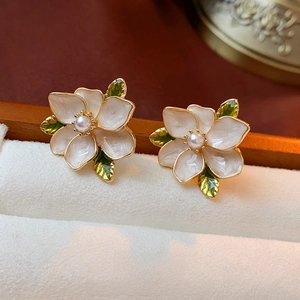 French vintage flower earrings with cream petals, green leaves, and central pearl detail