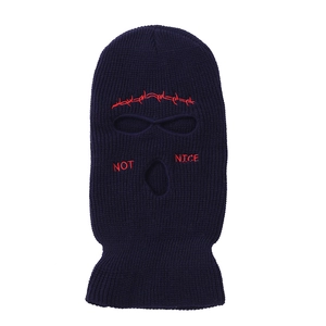 Detail of navy blue balaclava with red Not Nice text and thorn pattern embroidery