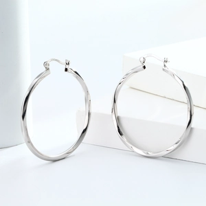 Detailed macro view of S925 sterling silver hollow twisted hoop earrings in silver