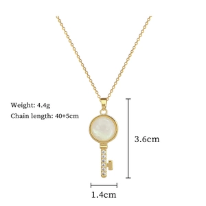 Detailed specs of gold key necklace with shell stone and dimensions 3.6cm by 1.4cm