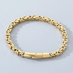 Macro shot of gold-plated Byzantine chain bracelet showing polished steel links and clasp