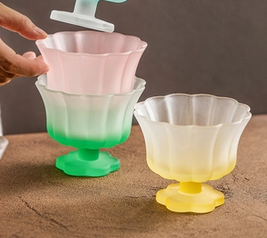Stackable frosted petal glass bowls in pink, green, and yellow with lids for desserts