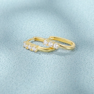 Macro detail of gold U-shaped S925 silver hoop earrings with four inset zircon stones