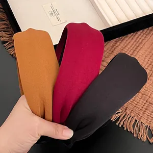 Detailed close-up of thick sponge headbands in mustard yellow, burgundy, and black fabric