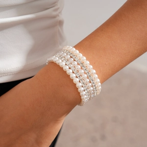 Macro detail of multi-layer bracelet with white pearls and sparkling rhinestone rows