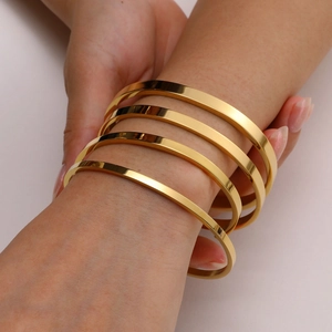 Minimalist gold-plated stainless steel C-shaped cuff bracelets set of 4 on a female wrist