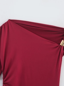 Detailed view of red ruched shoulder with elegant gold rectangular metal buckle trim
