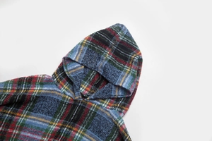 Detail view of colorful plaid woven fabric texture and hooded design on a poncho