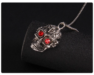 Gros plan détaillé du pendentif tête de mort punk avec yeux en strass rouges