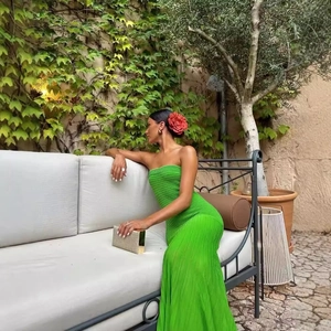 Elegant bright green pleated strapless maxi dress with slimming fit in a garden setting