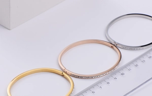 Detail of hinged gold and silver bracelets featuring side-set cubic zirconia accents