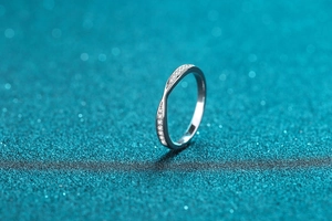Macro detail of S925 sterling silver ring with twisted band and pavé moissanite accents