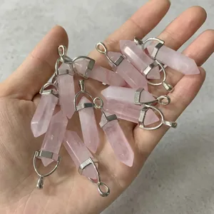 Detailed close-up of pink crystal hexagonal column pendants held in hand for inspection