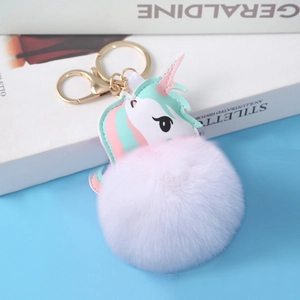 Detail of pink faux fur pompom keychain with a colorful PU leather unicorn charm