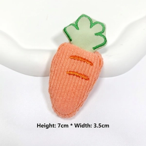 Detail view of 7x3.5cm stuffed carrot accessory with orange stripes and green embroidery