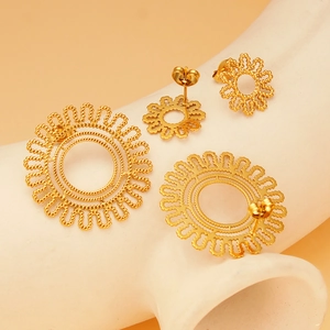 Detail of golden hollow sunburst stud earrings set in various sizes with rope texture