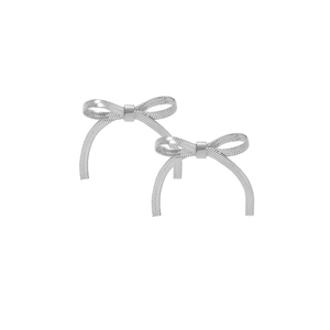 Close-up of silver bow earrings with detailed snake chain texture on white backdrop