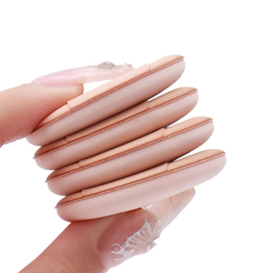Macro detail of four skin-colored mini finger powder puffs held by a manicured hand