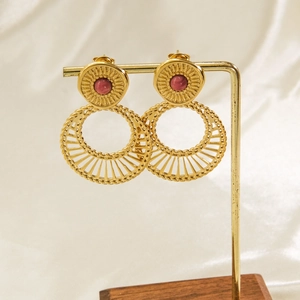 Detail view of Bohemian gold earrings with red stones on a vintage display stand