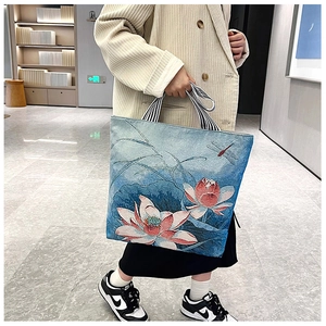 Detail of canvas tote bag with lotus print and striped handles for casual styling