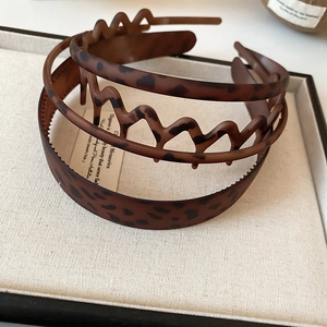 Detailed close-up of leopard print hair combs and headbands in warm brown tones