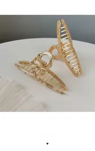 Detail of metal hair claw clips with marble texture resin in cream and amber finishes