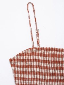 Detail of orange and white plaid fabric with elastic smocking and adjustable straps