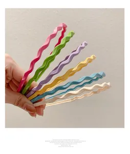 Close-up of wavy plastic headbands in various candy colors showing anti-slip texture