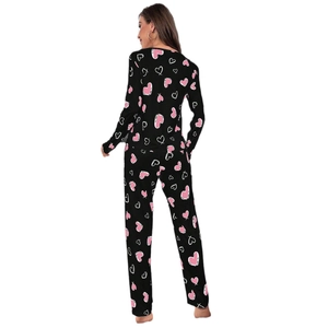Back view of women's black pajamas set with pink heart print and white hand-drawn patterns