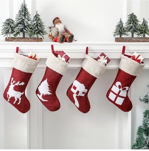 Set of four red Christmas stockings with reindeer and tree embroidery on a mantel