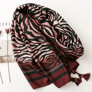 Detail of zebra pattern beach shawl with elegant tassel edges and red-black fabric