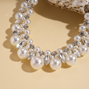 Detailed view of luxury baroque faux pearl necklace with sparkling rhinestones set on silver