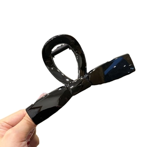 Glossy black bow-shaped hair claw clip for high ponytail styles and elegant hair styling
