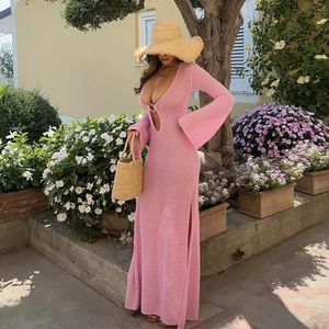 Detail of pink knitted beach dress featuring a deep V-neck and metal ring cutout design