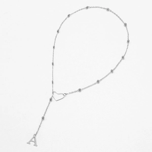 Close-up of silver Y-shaped necklace featuring a hollow heart and letter A pendant
