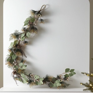 Close-up of crescent Christmas wreath with pine needles, cones and golden ornaments